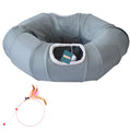 Gray donut-shaped pet bed with a tag and a small toy on a white background
